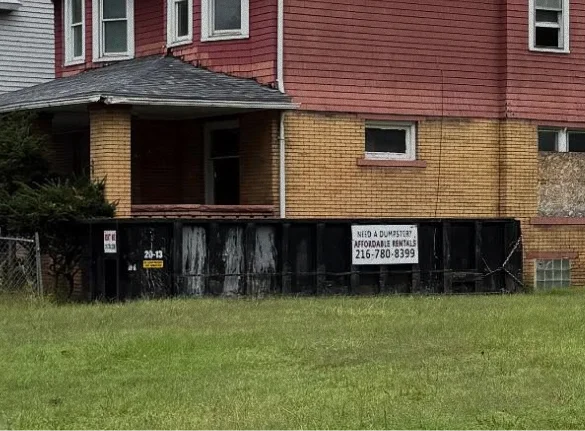 Black 20 yard dumpster rental placed in a residential driveway in Cleveland, OH